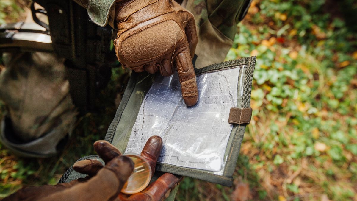 Two soldiers in the field looking at a map